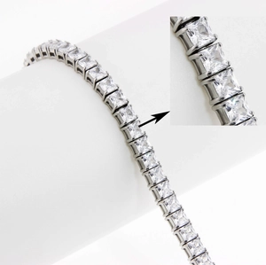Detailed macro view of silver tennis bracelet showing square-cut zircon and claw setting