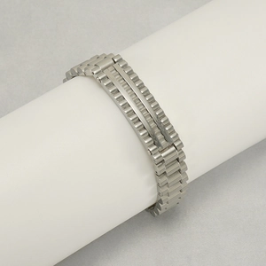 Bracelet pour homme en acier inoxydable poli argenté présenté sur un support à bijoux blanc