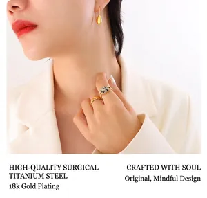 Detail of 18k gold plated titanium steel teardrop earrings and checkered ring set