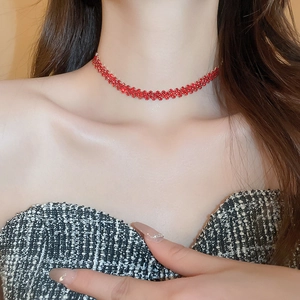 Close-up of elegant red rhinestone choker necklace on a model showing sparkling wave texture