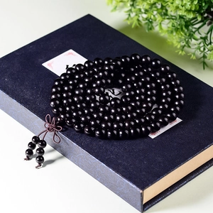Polished black sandalwood 108 mala prayer beads with purple tassel in a premium gift box