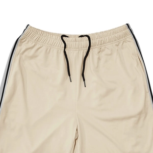 Detail of beige athletic shorts waist featuring black drawstring and side stripe accents