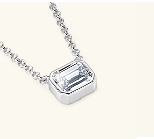Macro shot of an emerald-cut clear gemstone pendant in a silver bezel setting