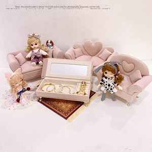 Pink velvet jewelry organizer with built-in mirror and ring slots shown with doll house props