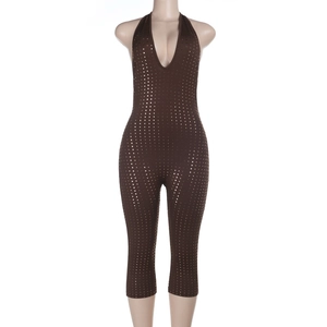 Detailed view of deep V-neck backless jumpsuit with shimmering gold polka dots