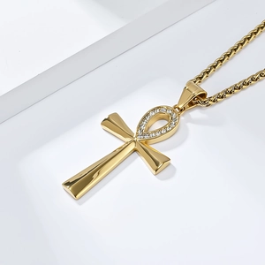 Close-up of golden Ankh cross necklace with clear rhinestones on woven chain link