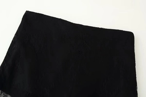 Close-up of intricate black lace floral pattern and hollow woven texture on the garment