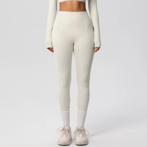 Detail shot of ivory high-waisted yoga leggings showing the side pocket and soft fabric texture