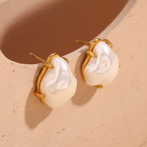 Detailed close-up of 18K gold plated Baroque pearl stud earrings on a ceramic rim