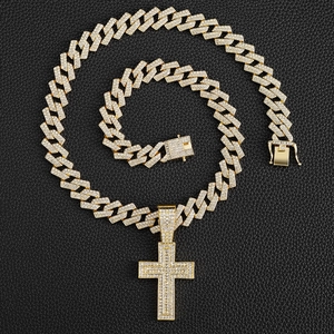 Detail of gold Cuban link necklace with iced-out cross pendant on black texture