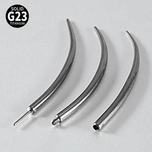 Macro shot of three G23 titanium curved barbells for body piercing on grey background