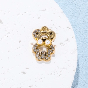 Golden bear pendant with pavé rhinestones and pearl eyes on a white stone background