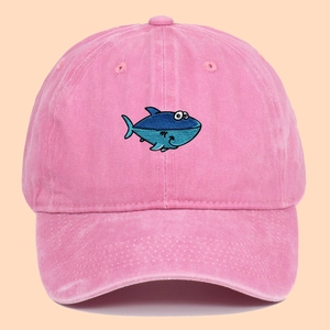 Pink washed cotton baseball cap featuring blue cartoon shark embroidery for outdoor sun protection