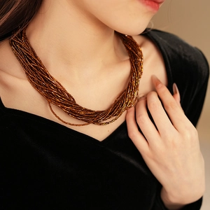 Dettaglio della collana multifilo di perline bronzo metallizzato in stile vintage francese