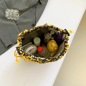 Sparkly gold and black sequin bucket bag showing large capacity and drawstring closure
