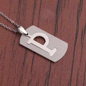 Vue macro d'un collier en acier inoxydable argenté avec un pendentif en lettre P majuscule