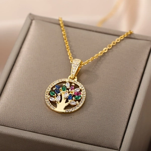 Golden Tree of Life necklace with colorful zircon stones on a gray jewelry box