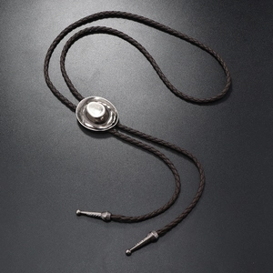Close-up of vintage silver cowboy hat pendant with brown braided leather bolo tie cord