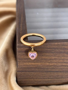 Macro shot of gold-plated stainless steel ring with a dangling pink heart zircon stone