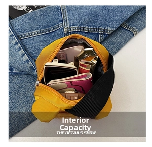Internal capacity of the yellow nylon cartoon dog handbag showing phone and sunglasses