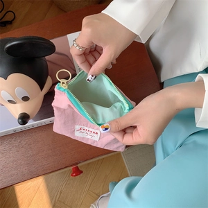 Detail view of the pink and mint green nylon cosmetic bag with circular zipper
