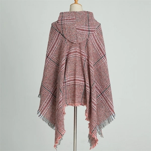 Detailed close-up of the red plaid hooded poncho featuring soft fringe tassels