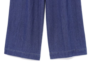 Dettaglio della trama del denim blu scuro e cuciture sull'orlo dei jeans a gamba larga