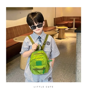 Gros plan du sac à dos vert pour enfant avec logo Girl Cats et poche zippée avant