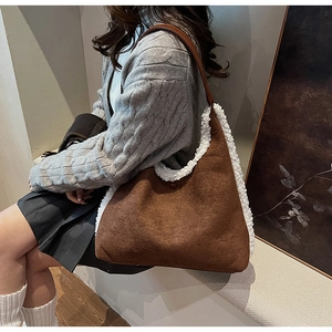 Detail of brown suede tote bag featuring white plush trim and soft faux fur lining