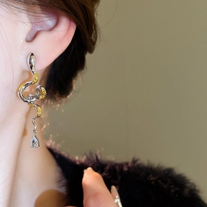Detail of silver snake earring with yellow enamel accents and teardrop zircon pendant