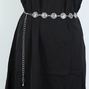 Detail of silver bohemian metal waist chain featuring coin pendants and hanging tassels