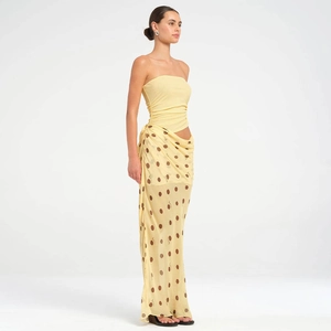 Détail du haut bustier jaune et de la jupe longue à pois avec découpe à la taille