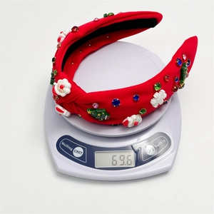 Detail shot of a festive Christmas headband with resin charms weighing 69.6g on a scale