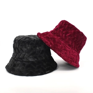 Close-up of plush bucket hats in black and wine red featuring herringbone embossed texture