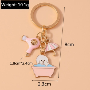 Detail view of pink dog in bathtub keychain with hair dryer and umbrella charms