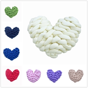 Selection of handmade knot braided heart-shaped pillows in various colorful woven yarns
