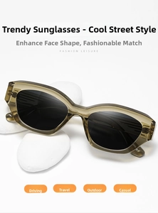 Detail of olive green translucent acetate frames and dark polarized lenses on stone