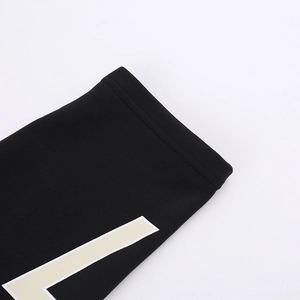Macro shot of knitted black fabric with beige geometric print and premium stitching detail