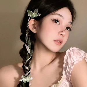 Detail of light green butterfly hair clip with silk ribbons styled in a braid