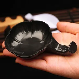Handheld black petal-shaped plastic calligraphy ink dish with a small handle