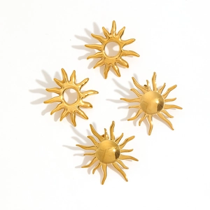 Detailed view of four golden stainless steel sun-shaped earrings on white background