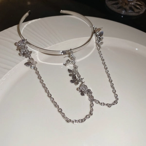 Detailed close-up of a silver butterfly tassel armlet featuring long metal hanging chains