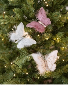 Close-up of sparkling sequin feather butterfly clip on Christmas tree with warm lights