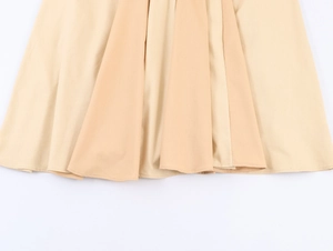Close-up of pleated apricot hemline showing detailed stitching and fabric texture