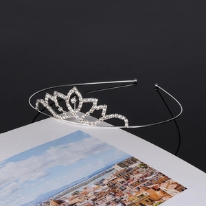 Silver bridal tiara with rhinestone crown design on an open book for elegant wedding style
