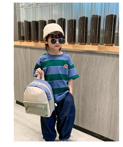 Kid modeling minimalist canvas backpack with fashion accessories in an outdoor setting