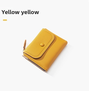 Detail view of yellow lychee texture wallet with snap button and side zipper closure