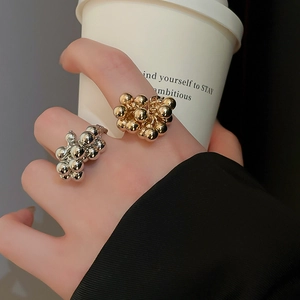 Irregular gold and silver beaded open ring shown in a modern lifestyle setting