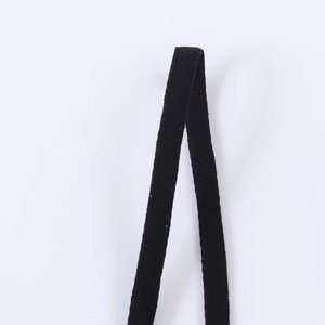 Close-up detail of the black lace asymmetric top showing high-quality fine webbing texture
