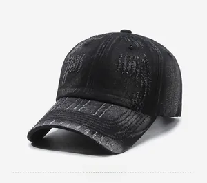 Detail view of distressed black denim fabric on a vintage baseball cap with ripped edges